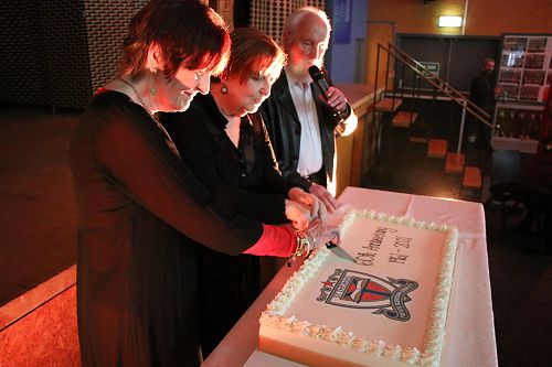 Maureen, Margaret and John cutting the cake at the 60th school reunion.