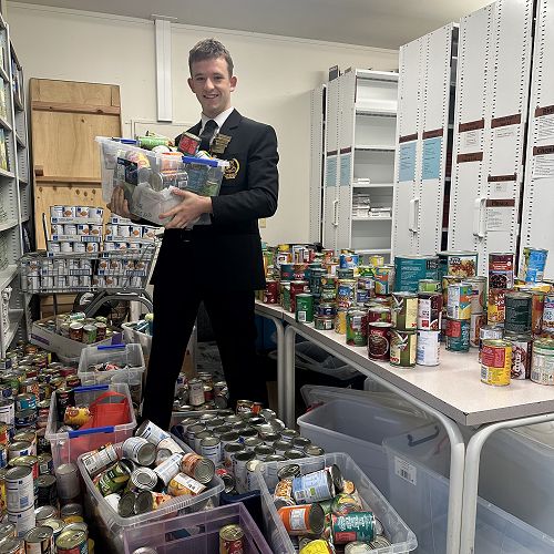 Head Prefect Hamish McKelvie helps sort some of the hundreds of donated cans