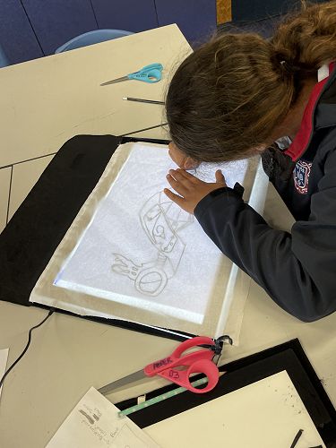 Using a light box to trace an image onto fabric.