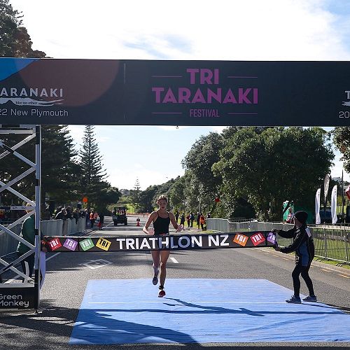Renee Carey takes the winning tape at NZSS Triathlon Championships
