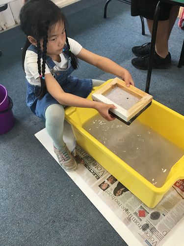 Janine draining the water from the paper.