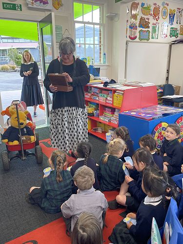 New Entrant class 2022 with Mrs Duthie handing out invitations for the end of year picnic