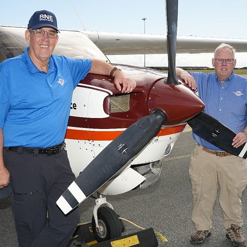 Rotarians from Ohio Peter Teahen and John Ockenfels standing on the tarmac at Brisbane International Airport