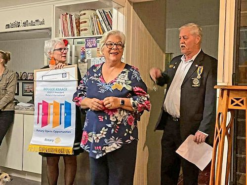 President Sharon Broughton accepts a banner for the newly chartered Barcie Club