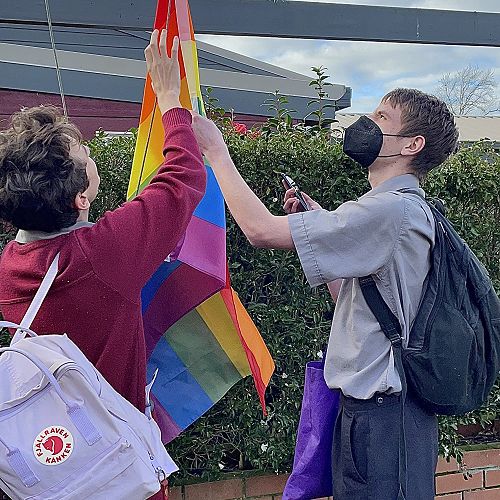 HEART Co-leaders Josef Gillgren and Wyatt Winke raise the Pride flag at HBHS