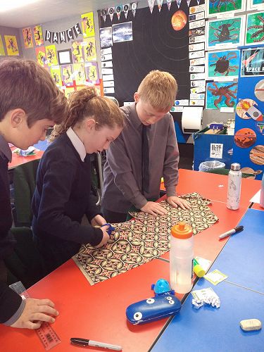 Gus Carr, Ailie Somerville and Fin Auchinvole cutting and measuring their fabric