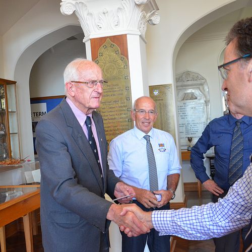 Brigadier Doctor Brian McMahon is congratulated from current teaching staff who are Old Boys' of the school. 