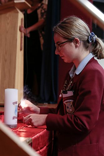 Briana Grace lighting the College candle at the beginning of the Holy Thursday Liturgy