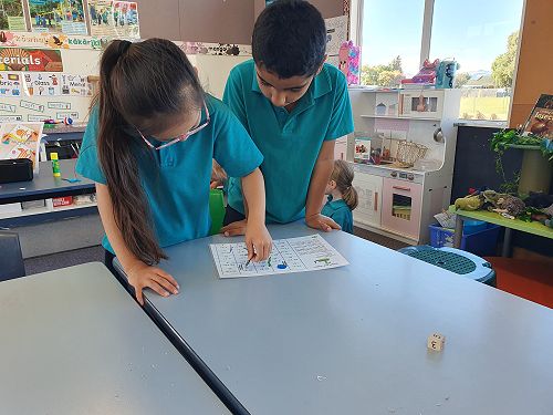 Irene and Jayan playing 'Addition/Subtraction Snakes and Ladders'