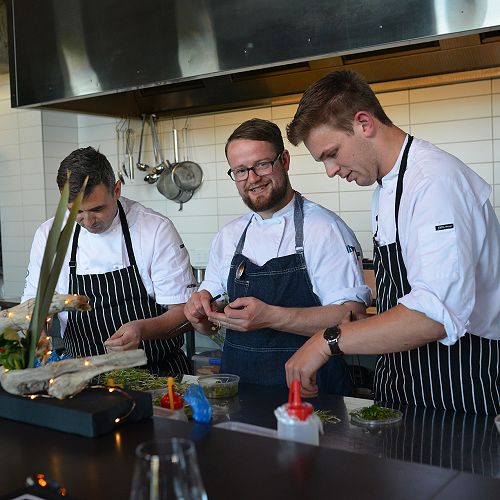 Adrian Woodhouse and students preparing a co-designed meal 