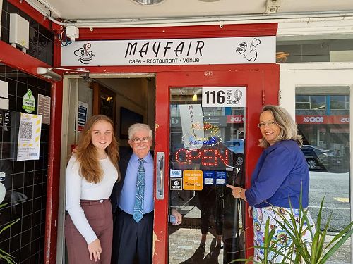 Placing stickers on Mayfair Café in Upper Hutt.