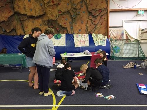 The evaluators watching as the team puts the board together.