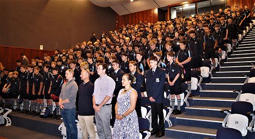 New students and staff standing inside the Performing Arts Centre while families enter.