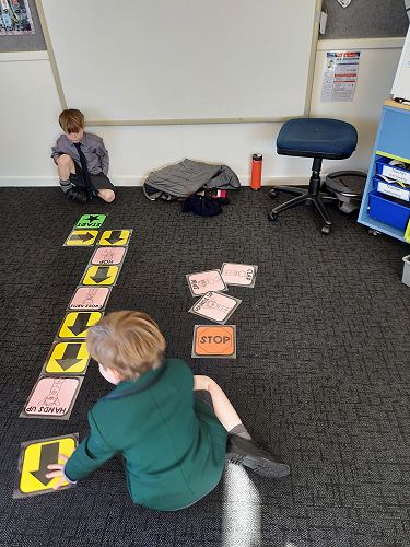 Ted and Harry creating and following coding action cards.