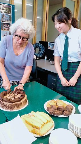 Ms. Riethmaier and Amber cutting the celebration cake.
