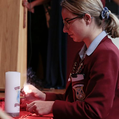 Briana Grace lighting the College candle at the beginning of the Holy Thursday Liturgy
