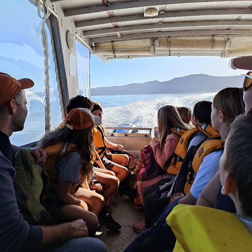 Class 4, on a boat, looking back at Kāpiti Island after their day trip there.