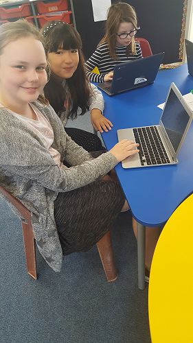 Isla and Holly creating a Powtoon about Draw my Life