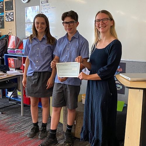 Bess Wilson and Oscar Searle presenting a cheque for $3,358.27 to the Cancer Society’s Zoe Arden.