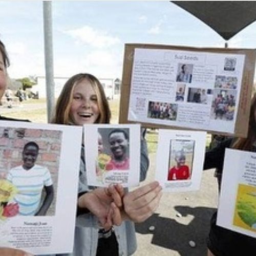 Nayland College students Daisy Scranney, left, Ruby Jones and Erica Batchelor hand out information at the school to promote the charity – Suzi Seeds in Sean's Footsteps – supporting the education of orphans in Uganda. 