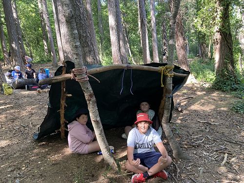 Isaac, Nathaniel and Danielle in the hut they made for the bush craft activity.