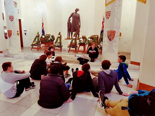 Ashley speaking to the students in the Hall of Memories about the ceremony. Wreaths laid by various dignitaries are visible in the back.