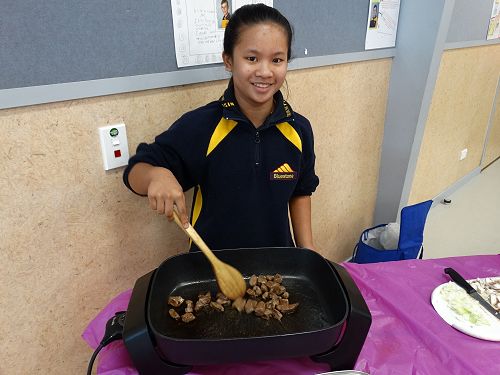 Charlize turning the meat to ensure it is evenly cooked