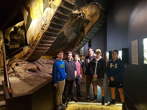 Sam Robb, Caleb Schiphorst, James Blenkinsop, Andrew Stopforth, Drew Hansen and Luke Dunn pose below the formidable replica of a British Mark V tank at the Great War Exhibition