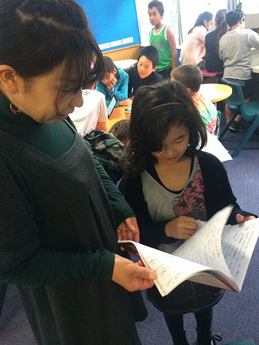 Seika shows her mum how much writing she has done this term as she has worked on her information report.