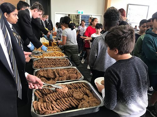 Students serve food to guests