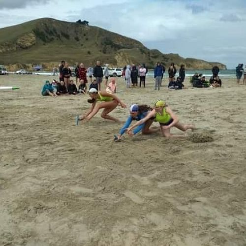 Ariana, (in the blue) leaps for the flag at the South Island Surf Lifesaving Champs.