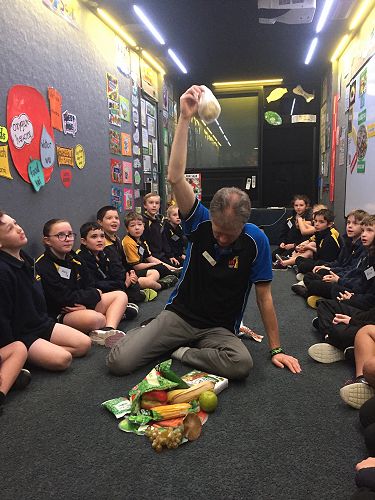 Rudi is holding up food that comes from the ground.