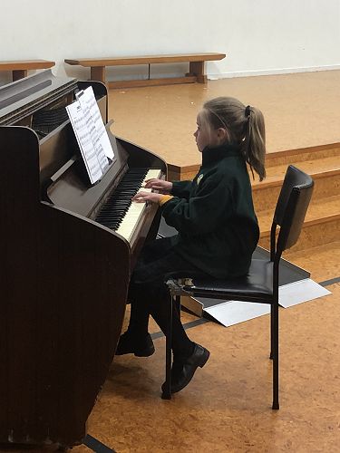 Abby on the piano performing.