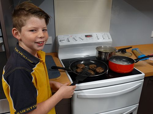 Connor making sure the patties are well cooked