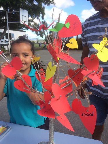 Jayda adding a heart to the gratitude tree.