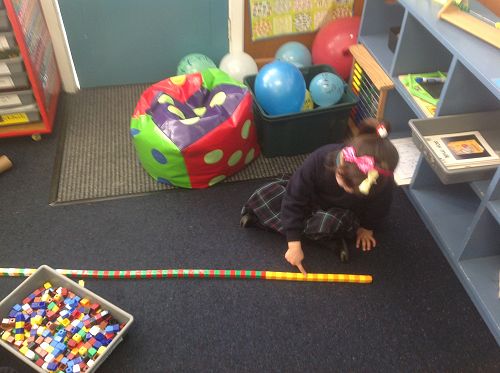 Alana is finding patterns using uni-blocks during Math goal inquiry time.