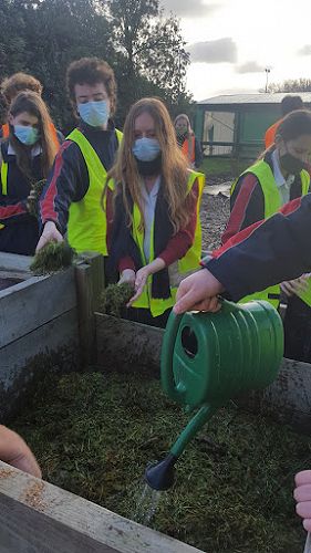 Miss McLeod's Level One Geography class learning how to make a good hot compost heap, adding water to brown dry carbon layers, alternating with nitrogen-rich green layers and micro-organisms as soil layers