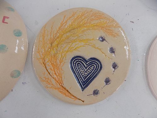 Flowers saved from the Heaton tributes printed into the clay and a Trade Aid heart.