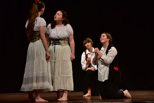 Demetrius and Lysander gaze lovingly at Helena while under the influence of a love potion.