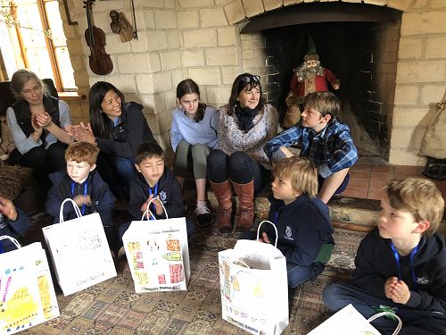 Children with their bag of goodies. Harriet, Justine and Guy Byfield sitting on the fireplace step.