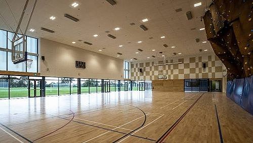 Gym with climbing wall and sports fields in the distance
