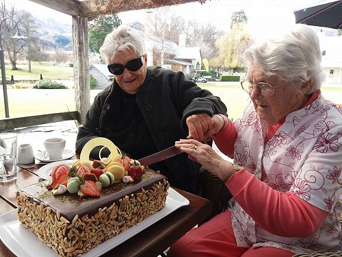 Agnes Wilson and Pat Wilson cut the cake, celebrat