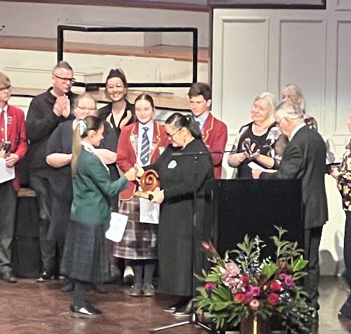 Miss G Hill, Arts Prefect 2024 and Choir Leader accepts the award for best Te Reo song