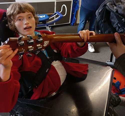 Charlotte loves time with Jim the music therapist. Here she is enjoying the vibration of the strings.