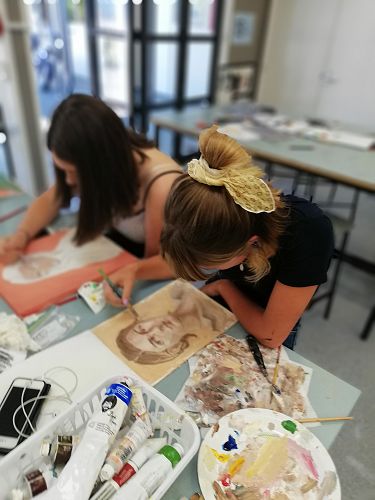 Maia absorbs herself in painting for her activity.