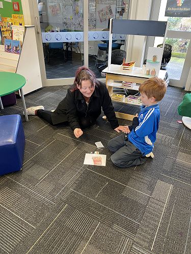 Lukus and his mum are playing knuckle bones.