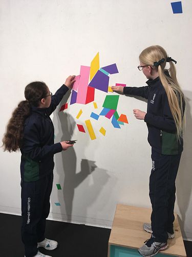 Bethan Mundy and Scarlett Wilson creating designs using magnetic shapes.