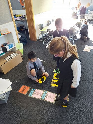 Liam, Addison and Poppy creating and following coding action cards.