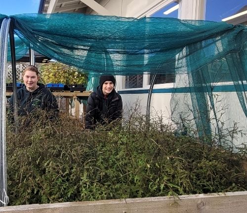 Delaney Black and Rykar Buchanan pose with some.of their nursery plants.