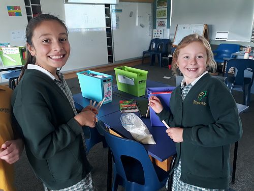 Lily and Holly tasting their ice cream mixture as part of their technology learning.